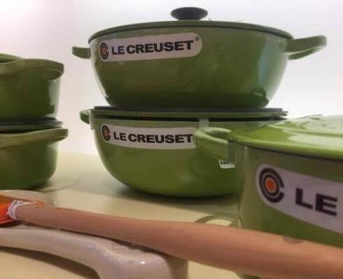 Why is the Le Creuset cast iron good ( picture of three Le Creuset French ovens on display).