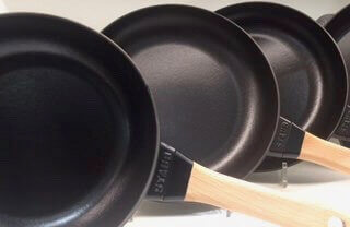Three Staub enamel cast iron. These fry pans come with a wooden handle and are a little lighter.