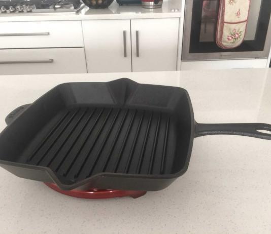 Black Staub grill pan on cherry red Staub trivet.