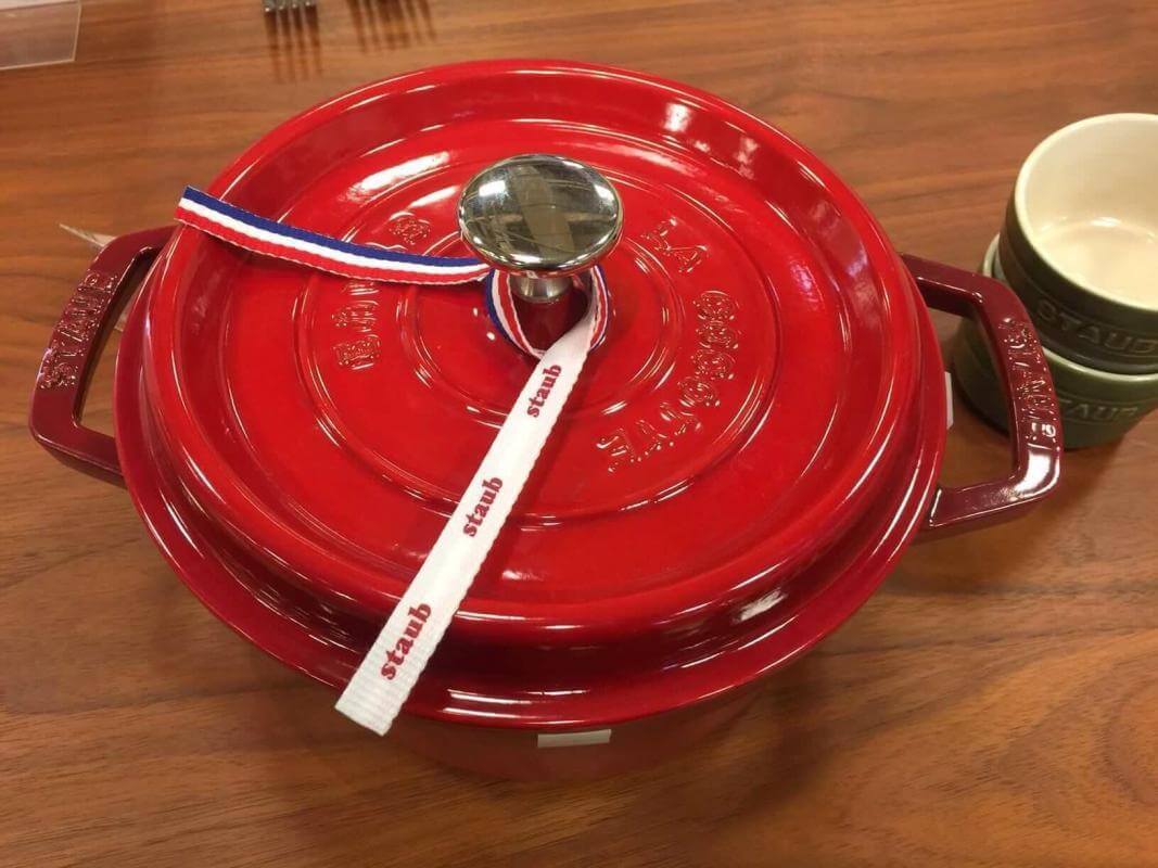 New Red Staub Dutch oven on a wooden table.