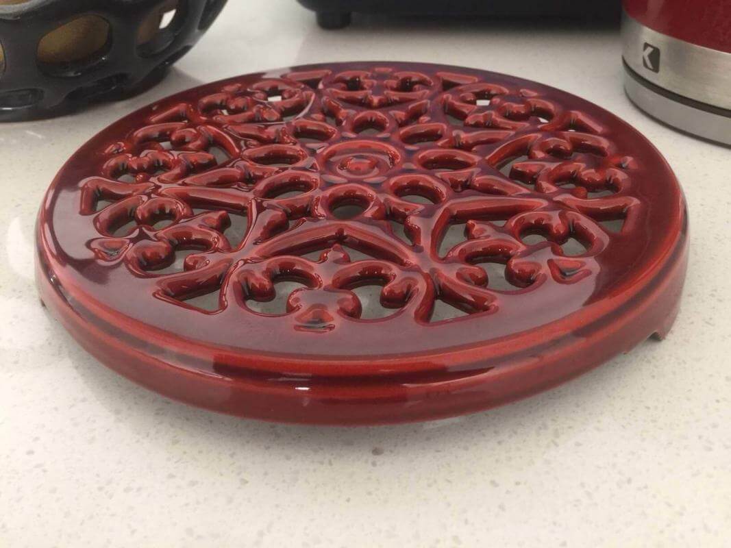 Cherry red trivet made by Staub cookware.