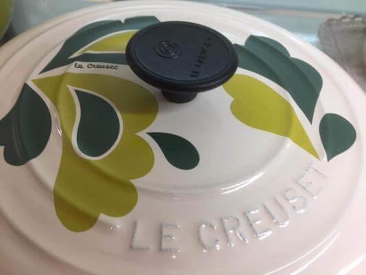 A white lid of a Le Creuset Dutch Oven. Find out why Le Creuset is more expensive.