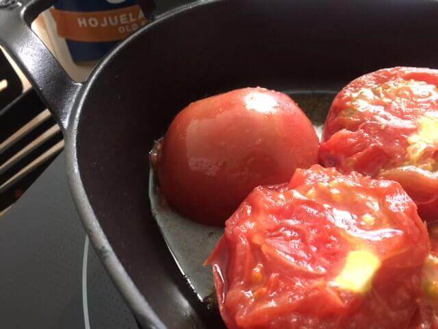 Tomatoes cooking in cast iron. What are the benefits of enamel cast iron? Well you can cook acidic foods such as tomatoes.