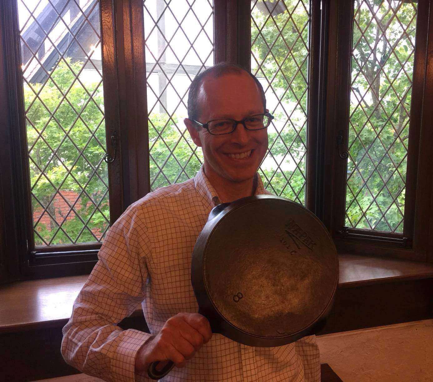 Brett from Boonie Hicks holding a vintage cast iron skillet made by Wapak Hollowware.