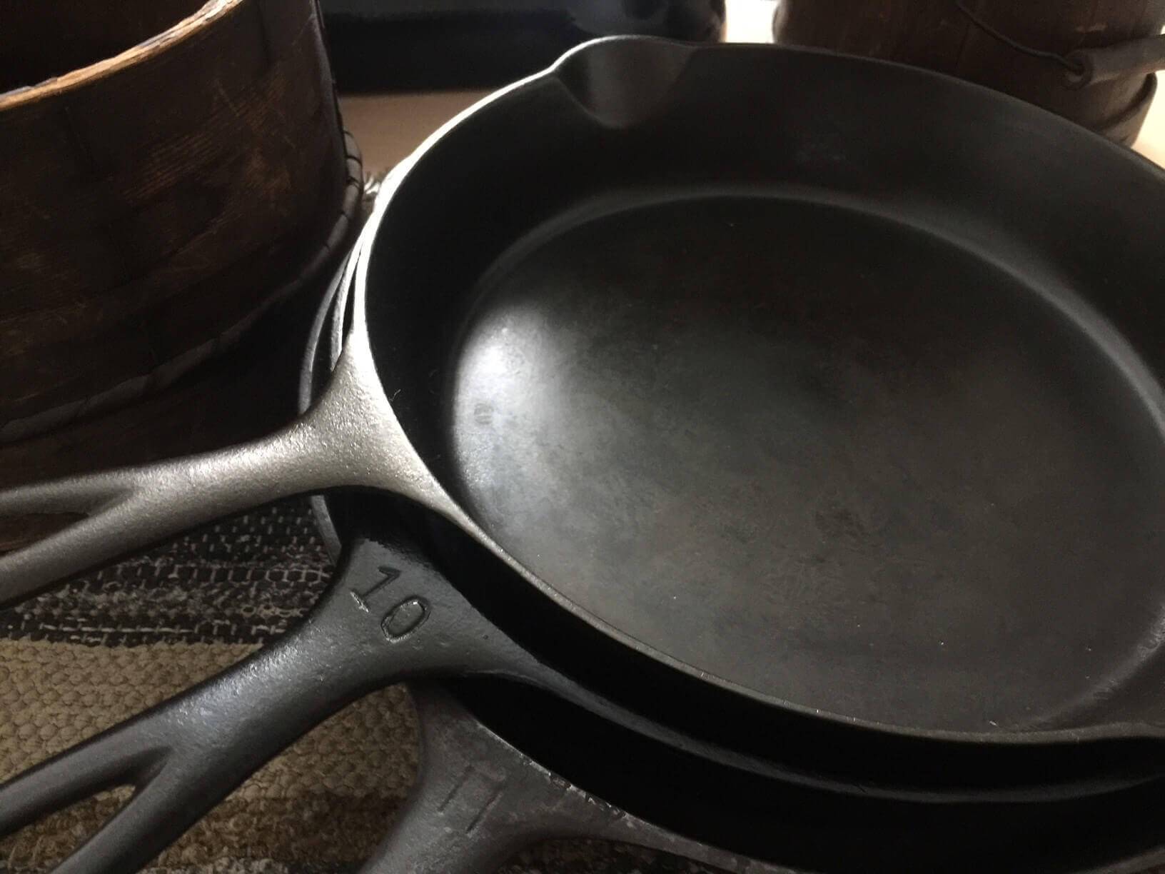 Three vintage cast iron skillets on a table. Which size is best.