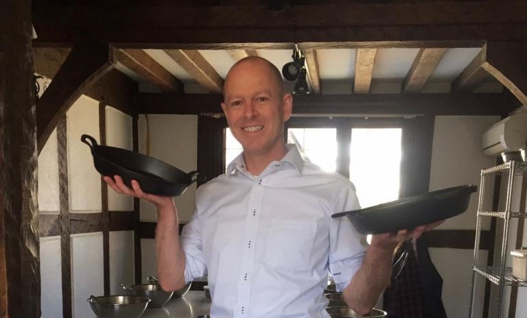 Cast iron vs enameled cast iron (Boonie Hicks member holding a seasoned skillet and an enameled cast iron dish).